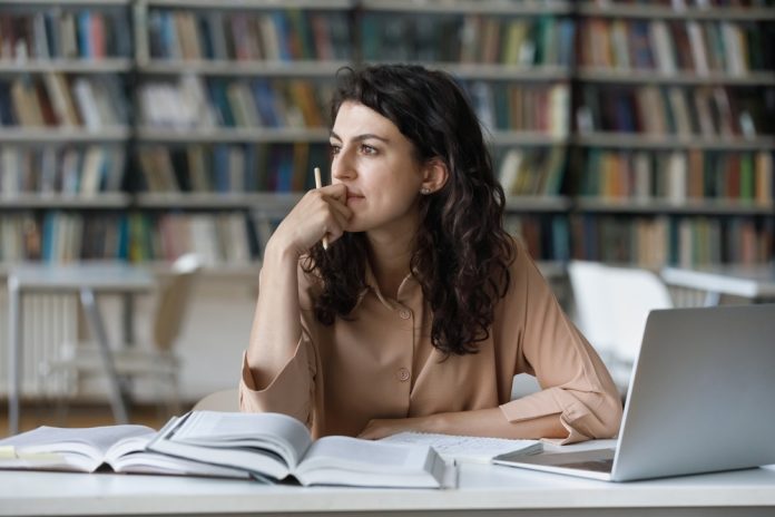 Young,Student,Girl,Sit,At,Table,With,Textbooks,And,Laptop