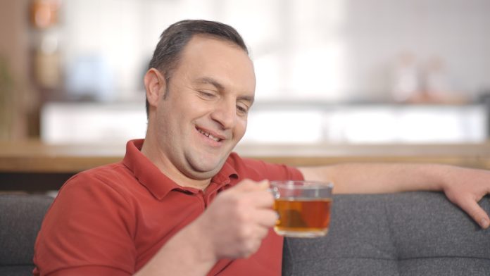 Young,Man,Sitting,Alone,At,Home,Drinking,Herbal,Tea.,Portrait