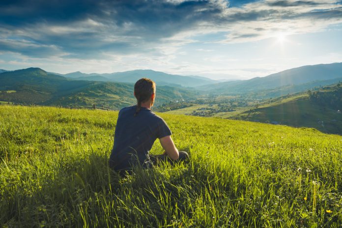 Tourist,Sitting,On,A,Hill,In,A,Green,Grass,And