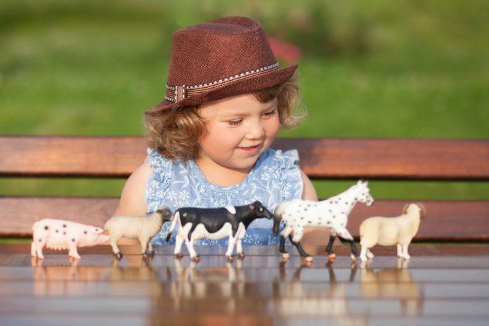 Cute,Toddler,Girl,Playing,With,Farm,Animal,Figures,Outdoors.,Summer