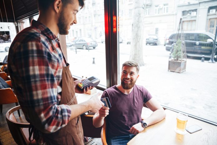Happy,Attractive,Bearded,Man,Drinking,Beer,In,Cafe,And,Paying